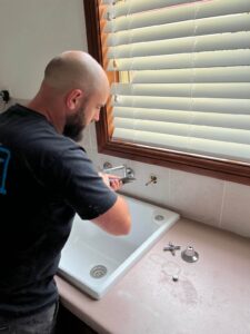Hills District Plumbing's plumber repairing a leaking tap
