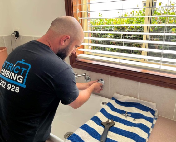 A plumber from Hills District Plumbing is servicing a tap in Beecroft