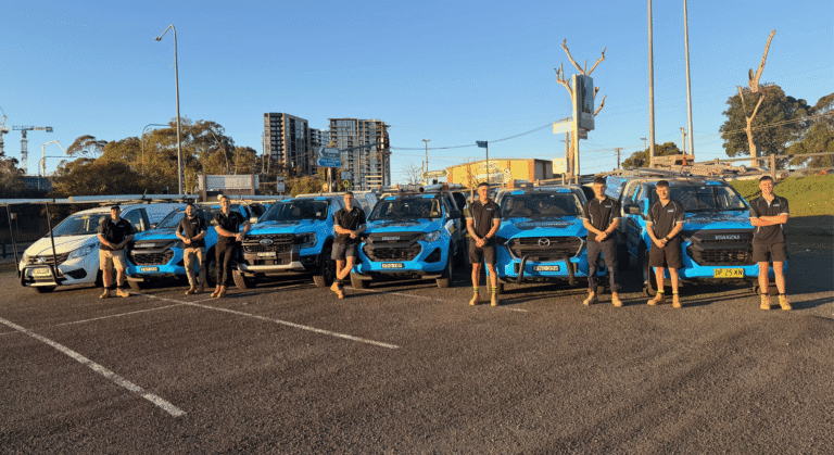 fleet of vehicles with plumbers standing beside vehicles